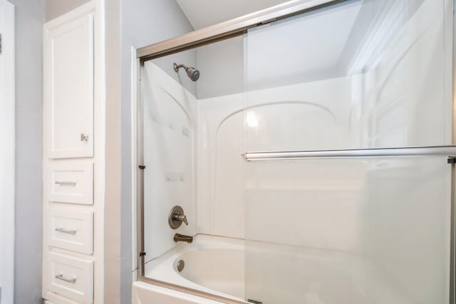 bathroom featuring combined bath / shower with glass door