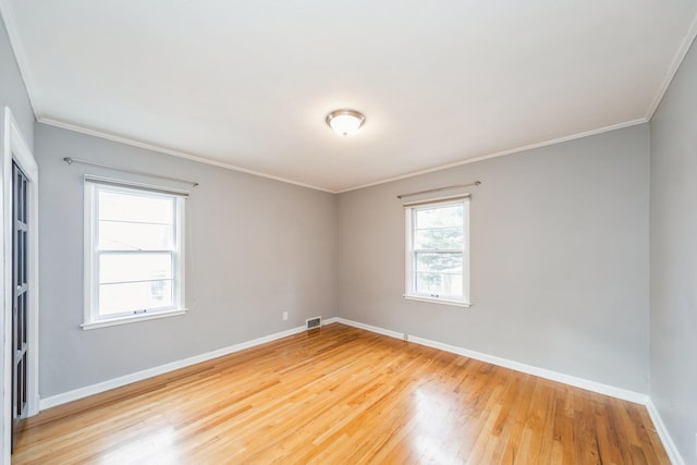 unfurnished room featuring ornamental molding and hardwood / wood-style flooring