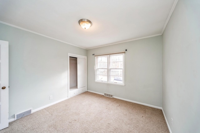 carpeted empty room featuring crown molding