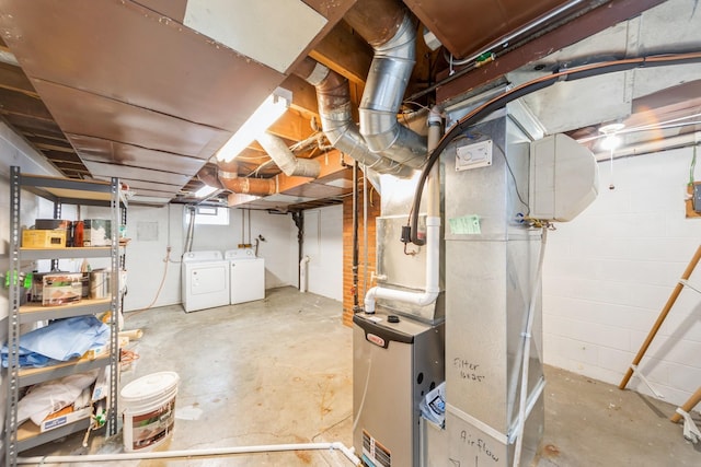 basement featuring heating unit and washing machine and clothes dryer