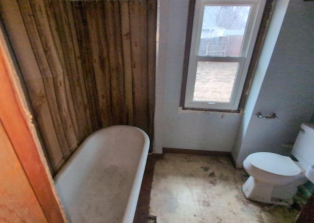 bathroom with a washtub and toilet