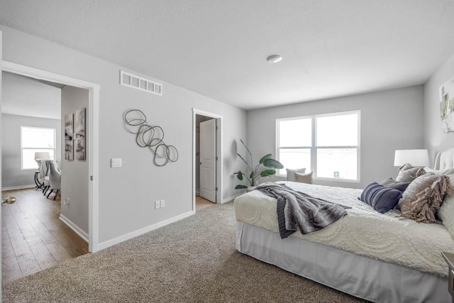 carpeted bedroom featuring baseboards and visible vents