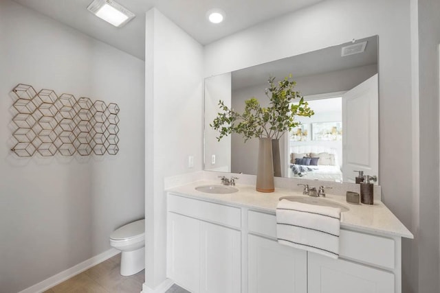 full bathroom with toilet, ensuite bath, double vanity, and a sink