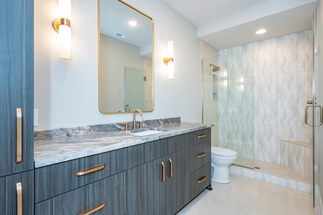 bathroom featuring a tile shower, vanity, toilet, and tile patterned floors