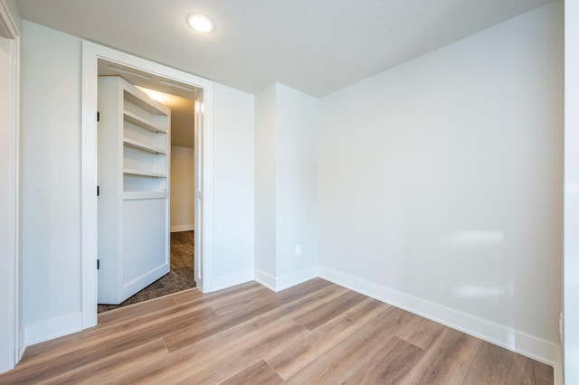 unfurnished bedroom featuring a closet and light hardwood / wood-style flooring