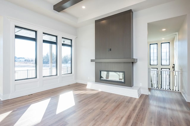 unfurnished living room featuring a fireplace and light hardwood / wood-style floors