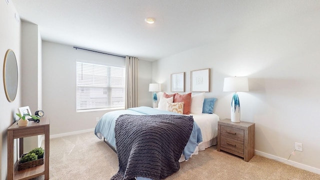 bedroom featuring light carpet and baseboards