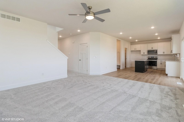 6918 SE 7th Ave, Pleasant Hill, IA 50327 - unfurnished living room with light colored carpet, recessed lighting, and ceiling fan