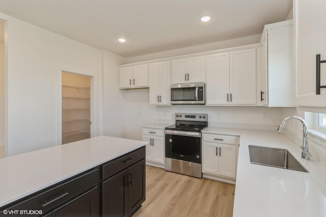 6918 SE 7th Ave, Pleasant Hill, IA 50327 - kitchen featuring stainless steel appliances, white cabinets, light countertops, light wood-style floors, and recessed lighting