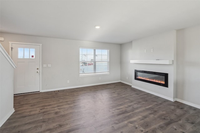 unfurnished living room with dark hardwood / wood-style flooring