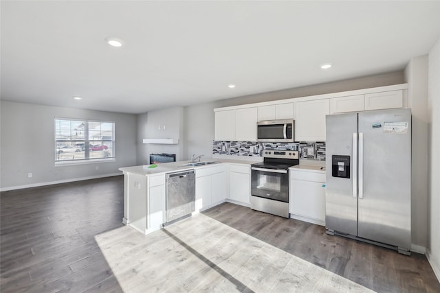 kitchen with white cabinetry, sink, kitchen peninsula, and stainless steel appliances