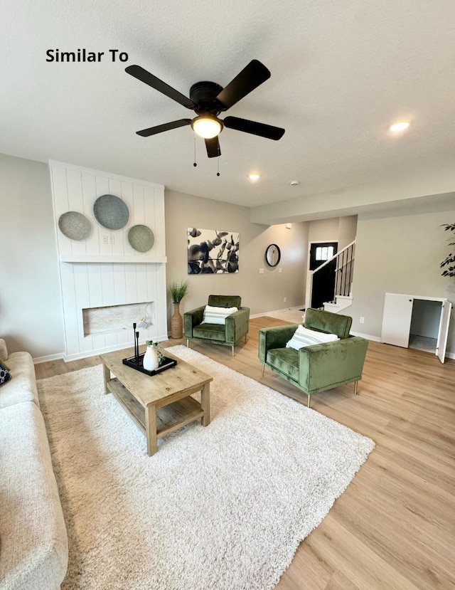 625 W Wright Rd, Norwalk, IA 50211 - living area featuring light wood-type flooring, a fireplace, baseboards, and a ceiling fan