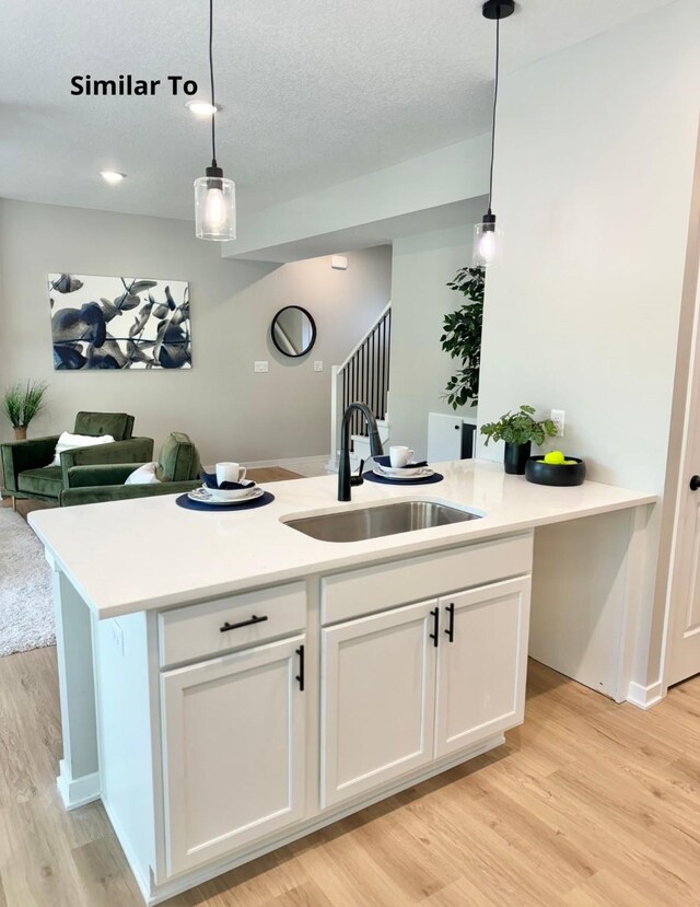 625 W Wright Rd, Norwalk, IA 50211 - kitchen with a sink, light wood finished floors, white cabinetry, and open floor plan