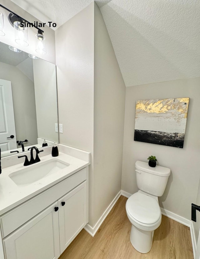 625 W Wright Rd, Norwalk, IA 50211 - bathroom featuring wood finished floors, toilet, vanity, a textured ceiling, and baseboards