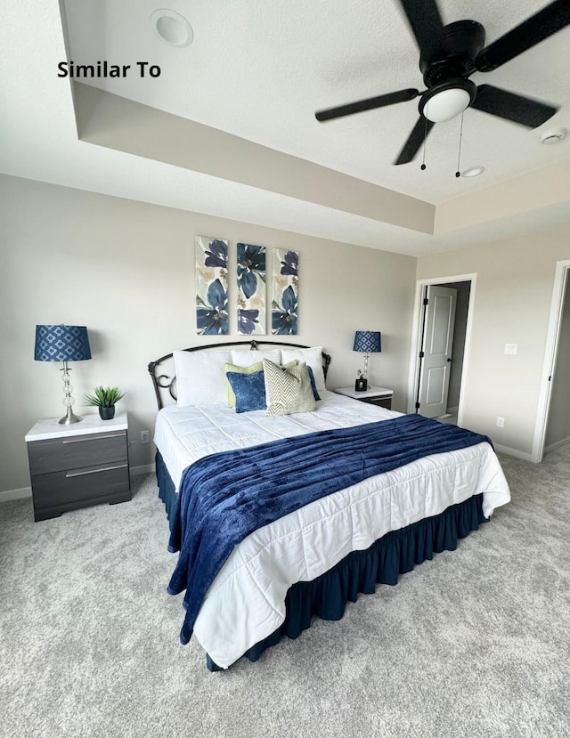625 W Wright Rd, Norwalk, IA 50211 - carpeted bedroom featuring a tray ceiling, baseboards, and a ceiling fan