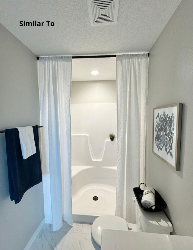 625 W Wright Rd, Norwalk, IA 50211 - bathroom featuring marble finish flooring, curtained shower, baseboards, and a textured ceiling