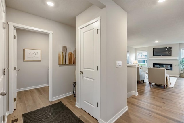 corridor with recessed lighting, baseboards, and light wood finished floors