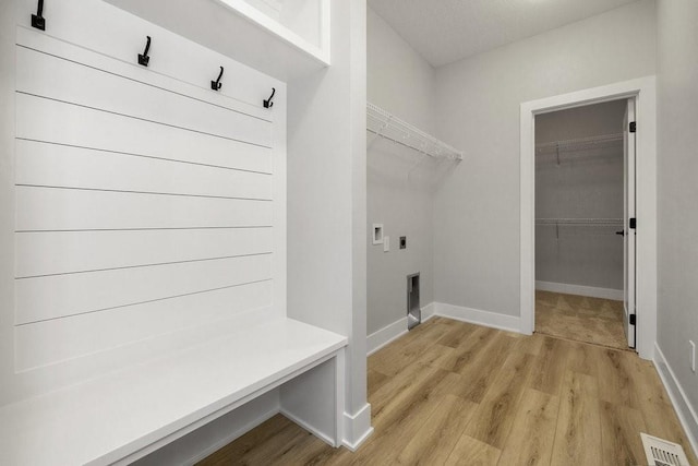 clothes washing area with light hardwood / wood-style flooring, washer hookup, and hookup for an electric dryer