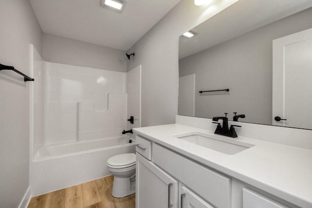 full bathroom with vanity, shower / bath combination, hardwood / wood-style flooring, and toilet