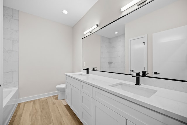 full bathroom featuring double vanity, a sink, toilet, and wood finished floors