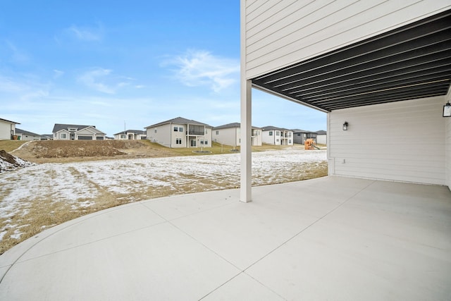 snow covered patio with a residential view