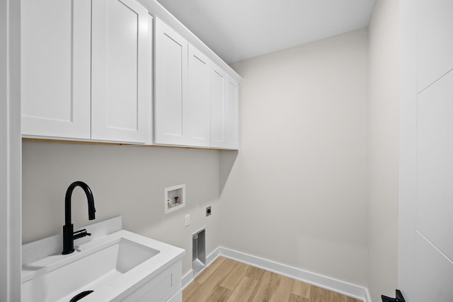 clothes washing area with washer hookup, a sink, cabinet space, light wood finished floors, and electric dryer hookup