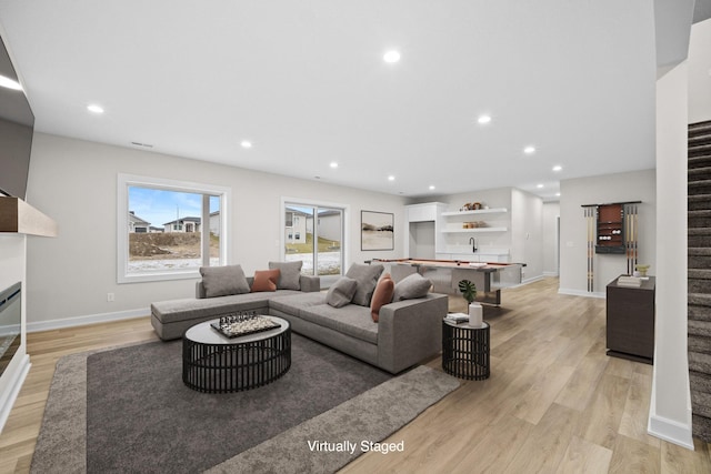 living room featuring sink and light hardwood / wood-style floors