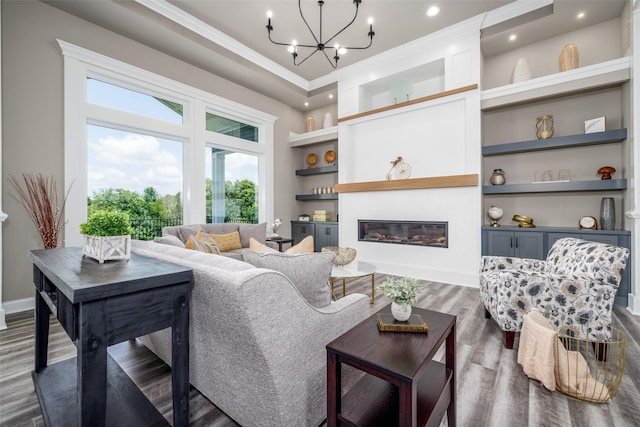 living room featuring ornamental molding, an inviting chandelier, built in features, and dark hardwood / wood-style floors