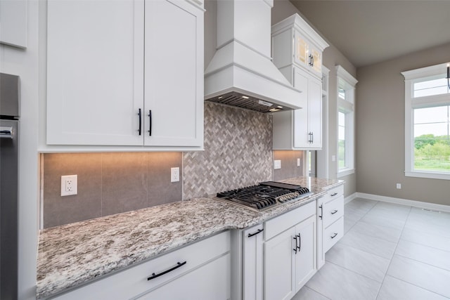 kitchen featuring custom exhaust hood, white cabinetry, and stainless steel gas cooktop