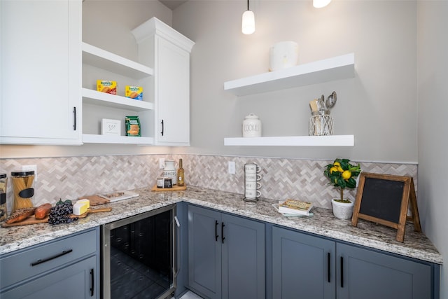 kitchen featuring white cabinets, decorative backsplash, blue cabinetry, hanging light fixtures, and wine cooler