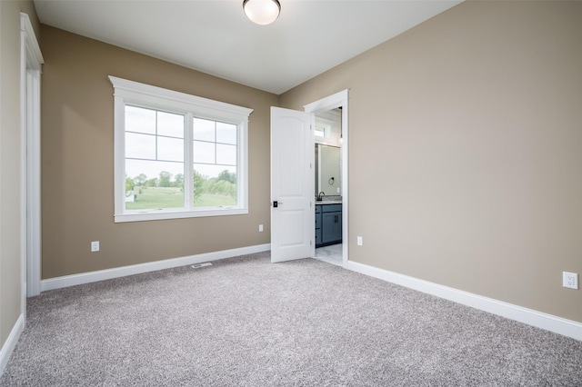 unfurnished bedroom featuring sink and light carpet