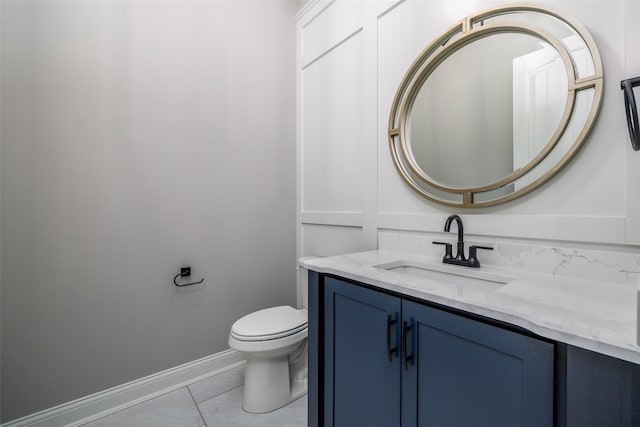 bathroom with toilet, vanity, and tile patterned flooring