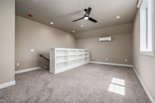 spare room featuring lofted ceiling, an AC wall unit, ceiling fan, and carpet