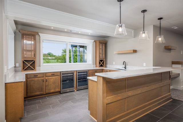 bar with sink, hanging light fixtures, beverage cooler, and dark tile patterned floors