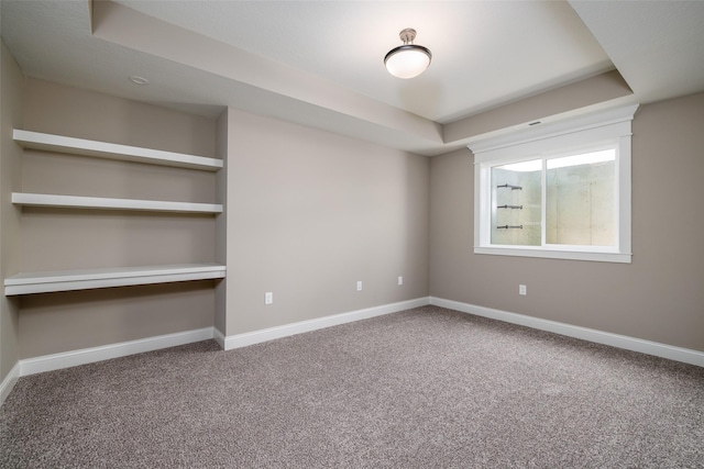 unfurnished bedroom featuring carpet flooring and a tray ceiling