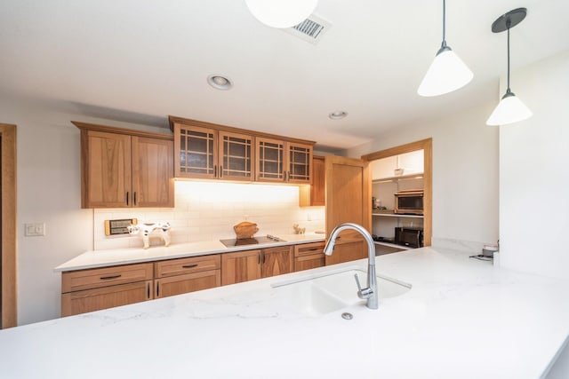 kitchen featuring sink, hanging light fixtures, black electric cooktop, and tasteful backsplash