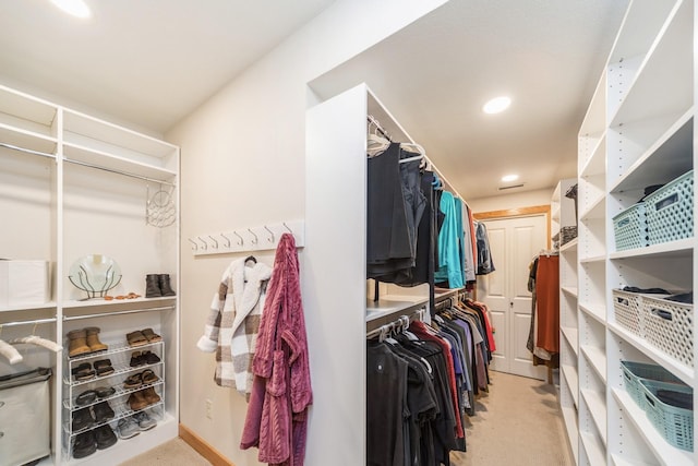 walk in closet featuring light carpet