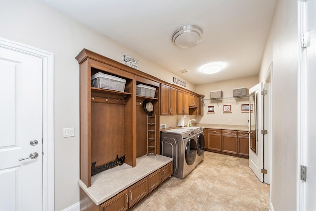 washroom with washer and dryer, cabinets, and sink