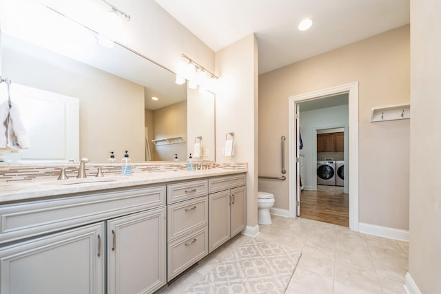 bathroom with toilet, independent washer and dryer, tile patterned flooring, and vanity