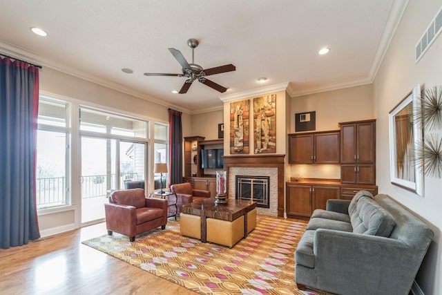 living room featuring light hardwood / wood-style floors, ceiling fan, and ornamental molding