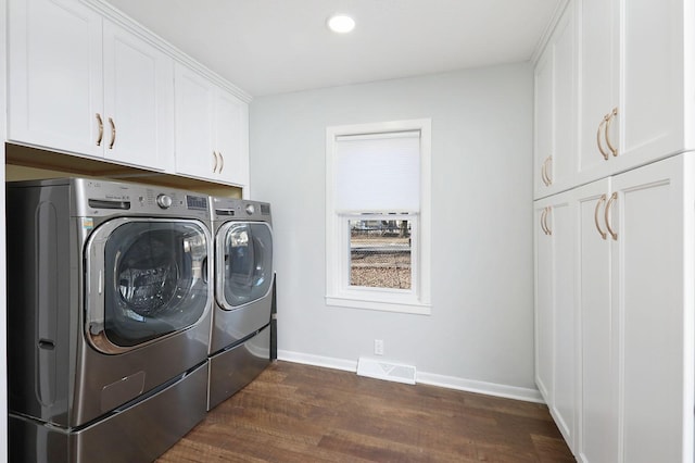 laundry area with separate washer and dryer, cabinets, and dark hardwood / wood-style floors