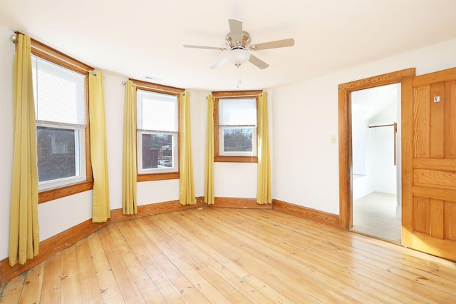 empty room with light wood-type flooring and ceiling fan