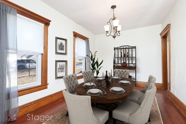 dining room featuring a chandelier, a healthy amount of sunlight, and dark hardwood / wood-style floors