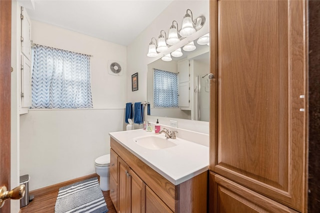 bathroom featuring toilet, wood-type flooring, and vanity