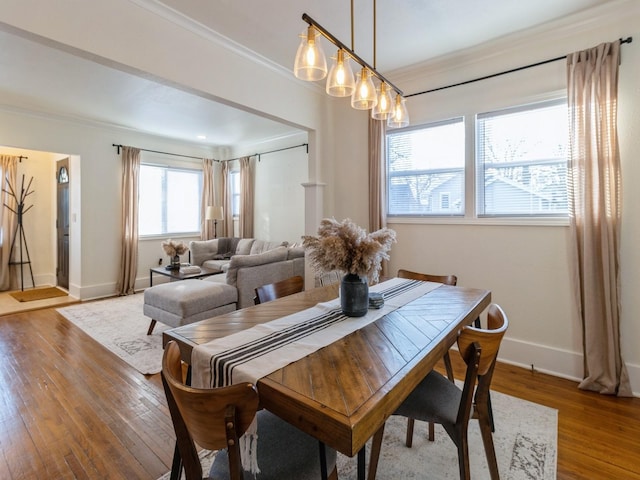 dining room with wood-type flooring and ornamental molding