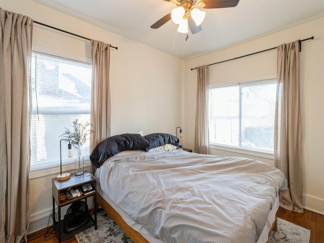 bedroom featuring wood-type flooring, multiple windows, and ceiling fan