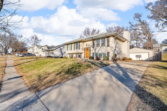 view of front facade featuring a garage, a front yard, and an outdoor structure