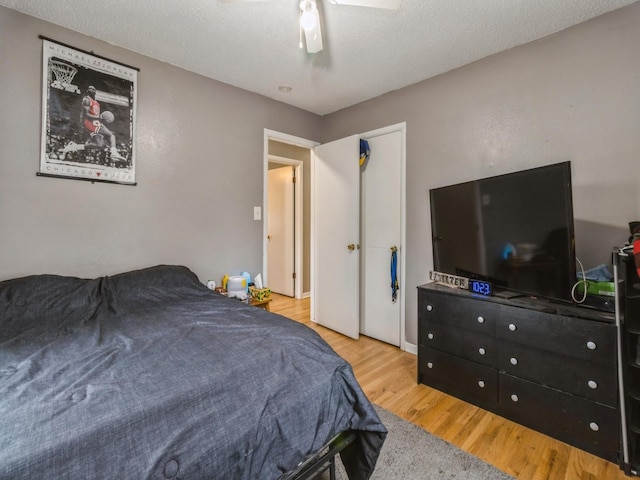 bedroom featuring a textured ceiling, ceiling fan, and light hardwood / wood-style flooring