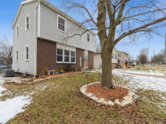 view of front of house featuring a yard and central AC unit