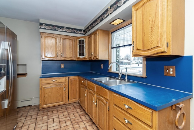 kitchen with sink, a baseboard heating unit, and stainless steel refrigerator